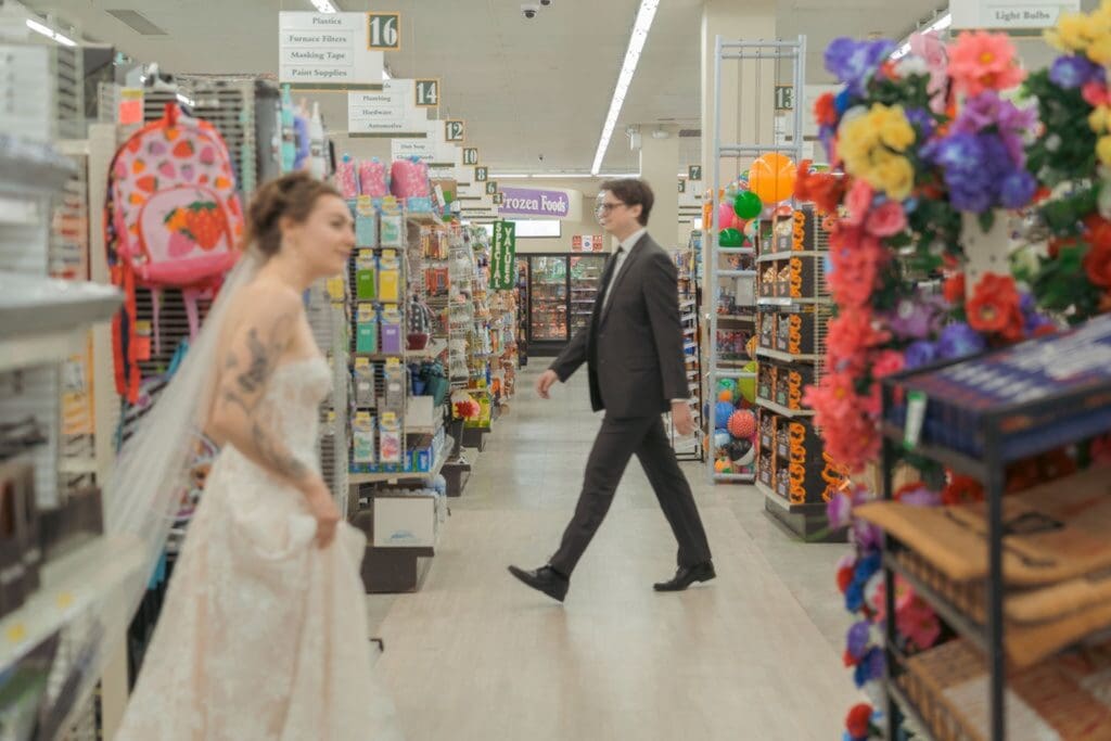 Bride and groom lost in a grocery store looking down the aisles for each other