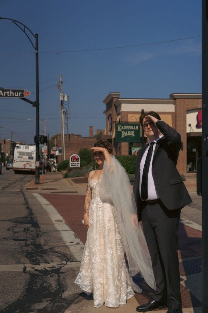 Bride and groom crossing a crossing lane on a bright sunny day