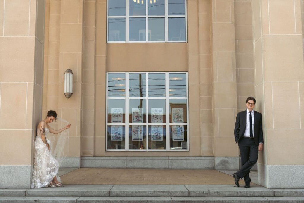 Editorial photo of a bride and groom standing outside an old library