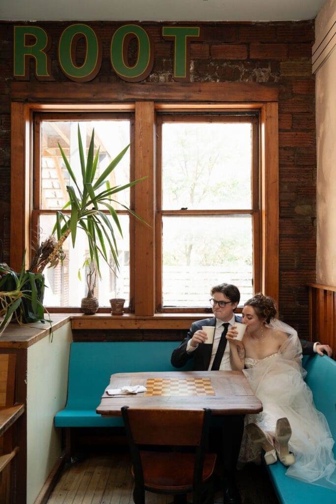 Photo of a Bride and groom sitting in a cafe drinking coffee