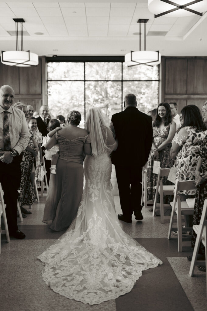 Bride's mom, dad, and daughter walking bride down the aisle