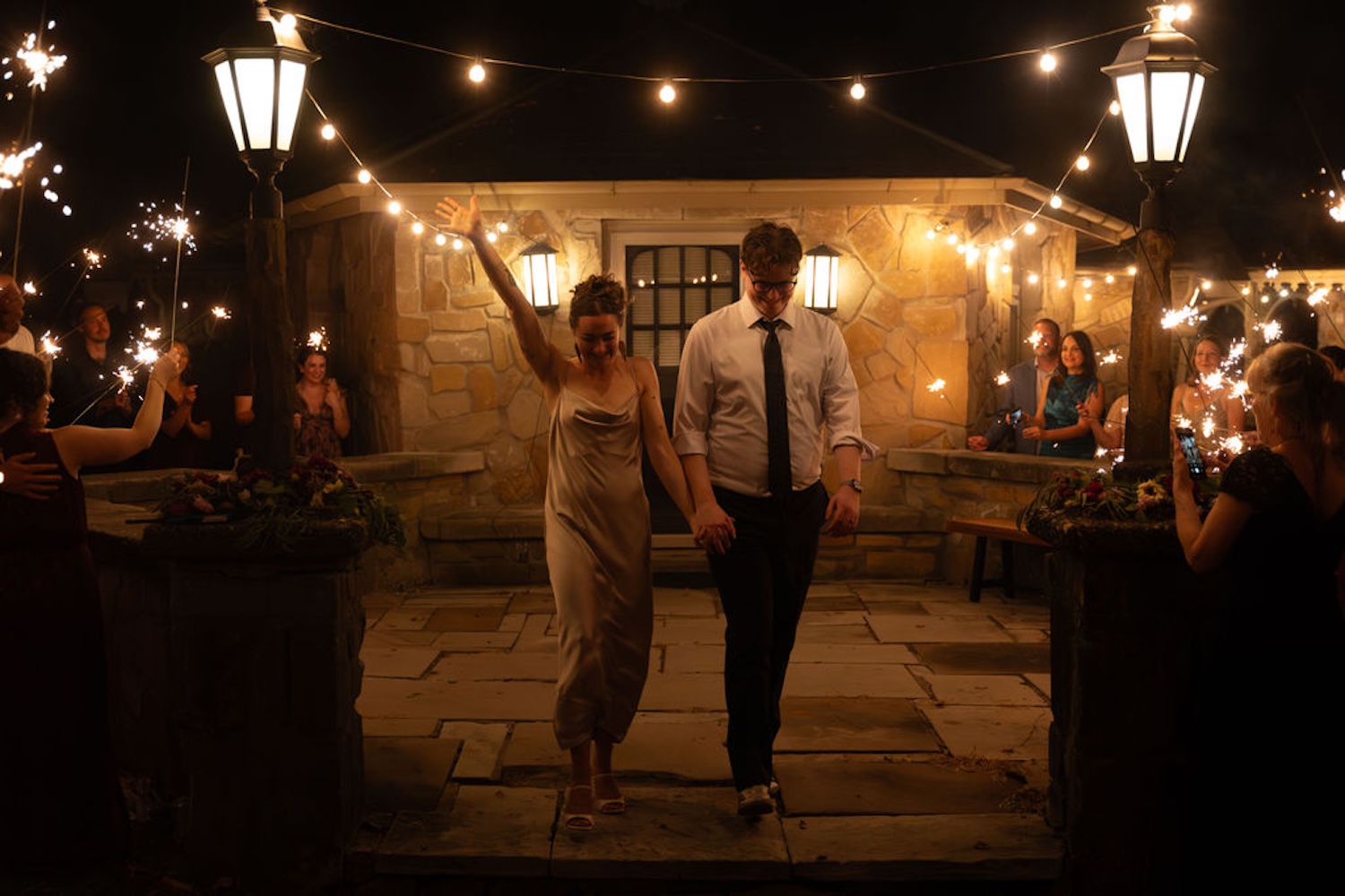 Bride and groom dancing their last dance while guests hold sparklers
