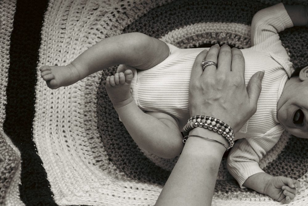 Baby crying while mom tries to soothe her in her bassinet